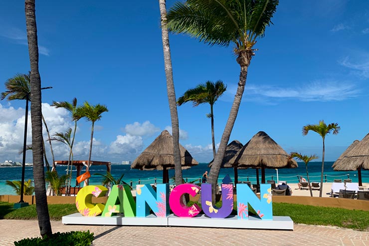 Cancún sign with sea in the background