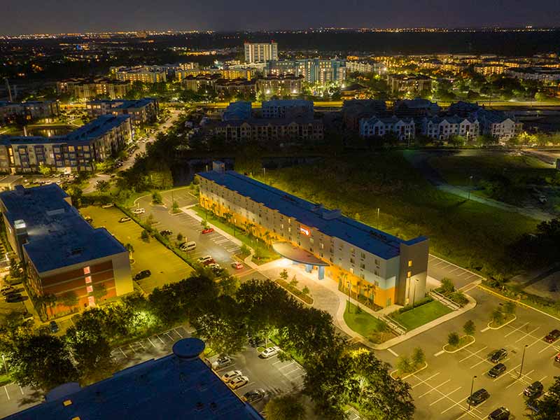 Aerial view of Spot X with some cars parked in front of it in the parking lot