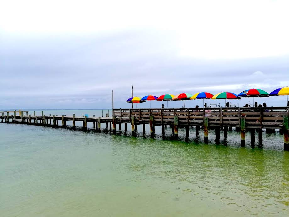 Chairs with colorful umbrellas on the pier at Deweys Restaurant in Destin 