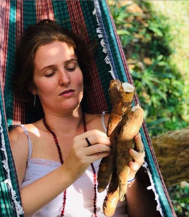 lying in a hammock, holding a cassava