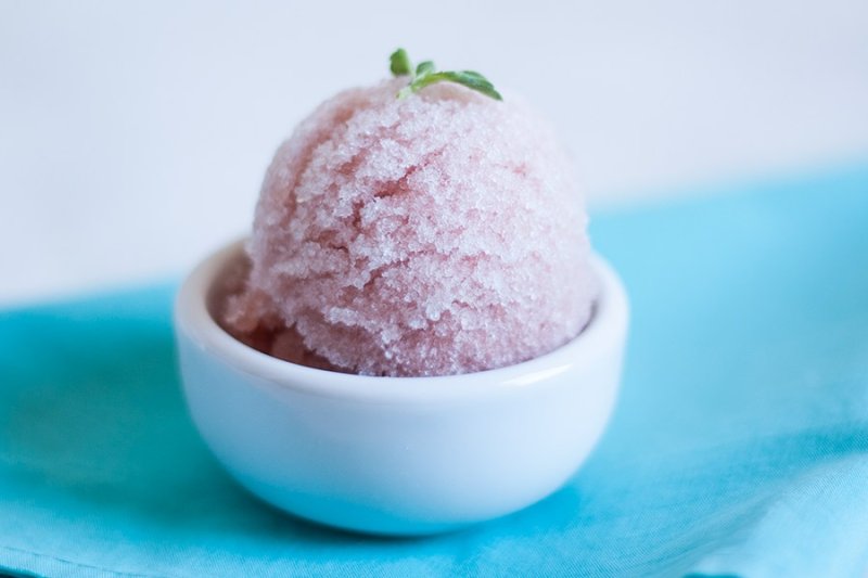 A scoop of watermelon ice cream with a basil leaf by PratoFundo.com