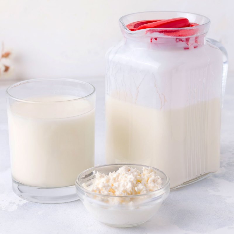 Kefir in a glass and a jar, and a small pot with kefir grains.