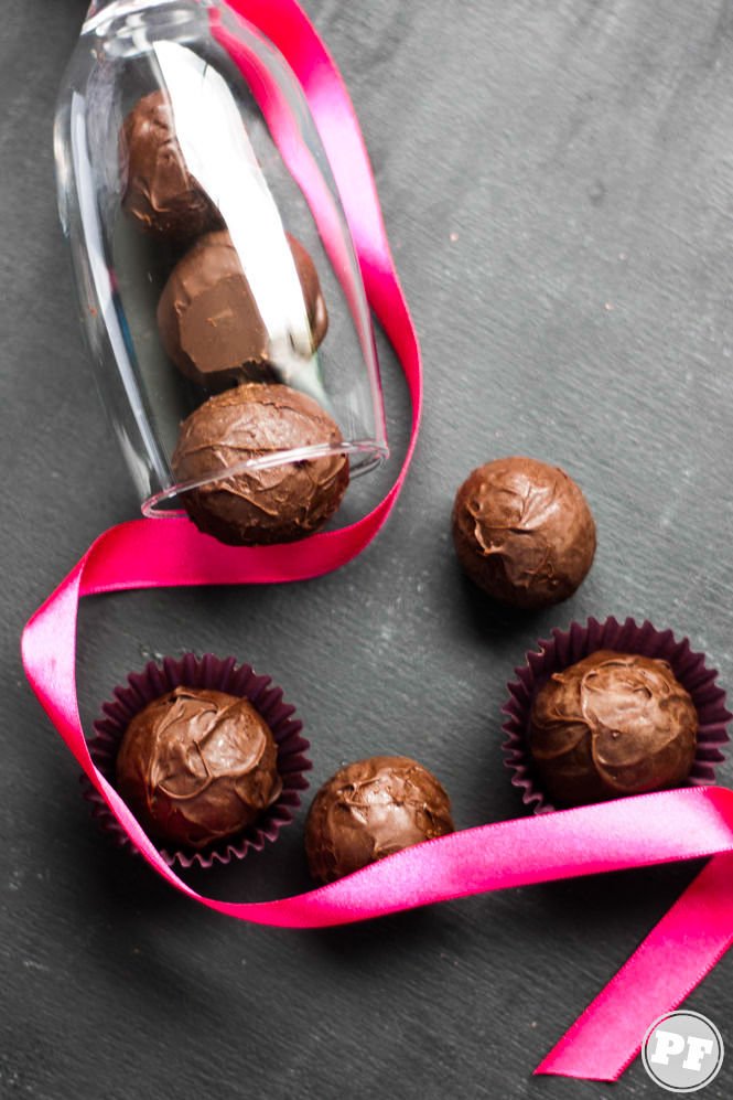 Champagne truffle on a dark table with a pink ribbon and inside a flute glass