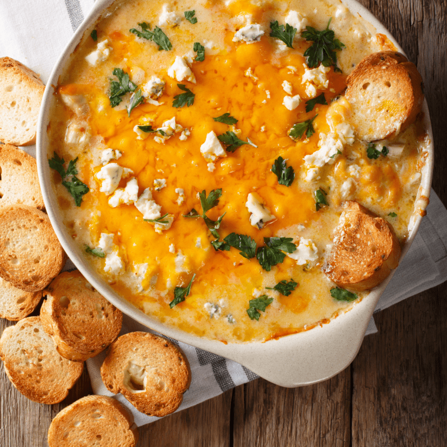 Trempette au poulet Buffalo dans une poêle ronde servie avec des baguettes