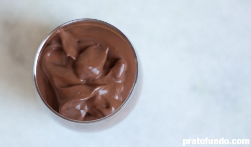 Chocolate mousse inside a glass cup on table top view