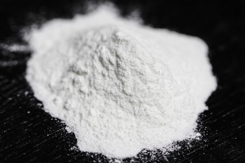 White powder of chemical yeast in close-up on dark background