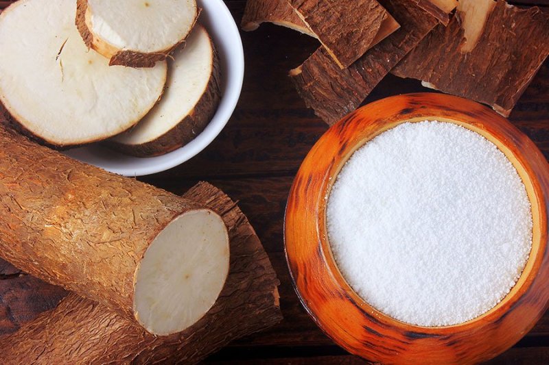 Clean and unpeeled cassava on a table and tapioca