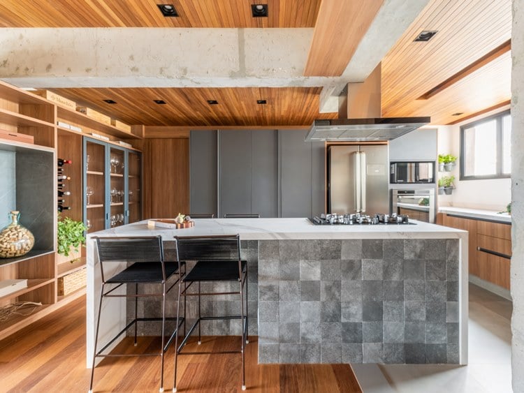 Apartment kitchen of 187 m² decorated by architect Pietro Terlizzi, island on the external side, with 2 black stools and a small mixed gray floor texture