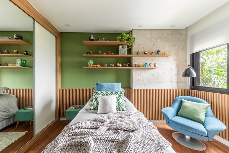 Youngest son's room, green colors and neutral tones, bed with green, blue and gray linen.  Blue armchair with green cushion.  Above the headboard of the bed, shelves with plants and animals decorating