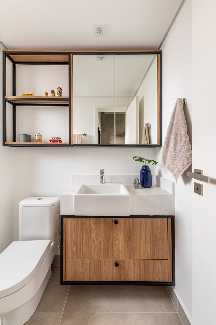 Bathroom in the brother's room, with sink, toilet and hanging cabinet with mirror and partitions decorated with perfume, mini cars and others