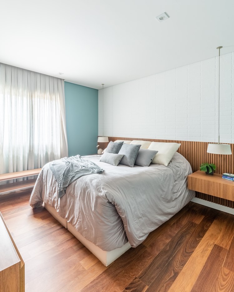 Double bedroom with very comfortable king size bed.  Brick wall and suspended wooden corner table, with lamps hanging from the ceiling.