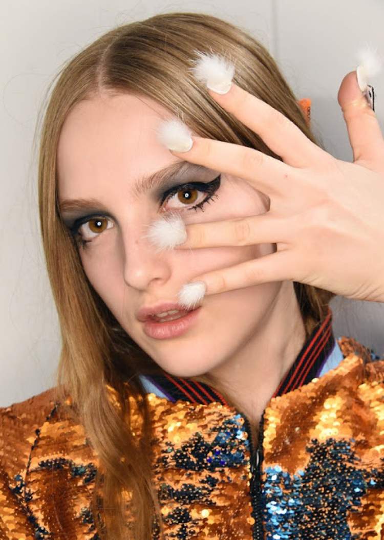 woman wearing pompoms on her nails