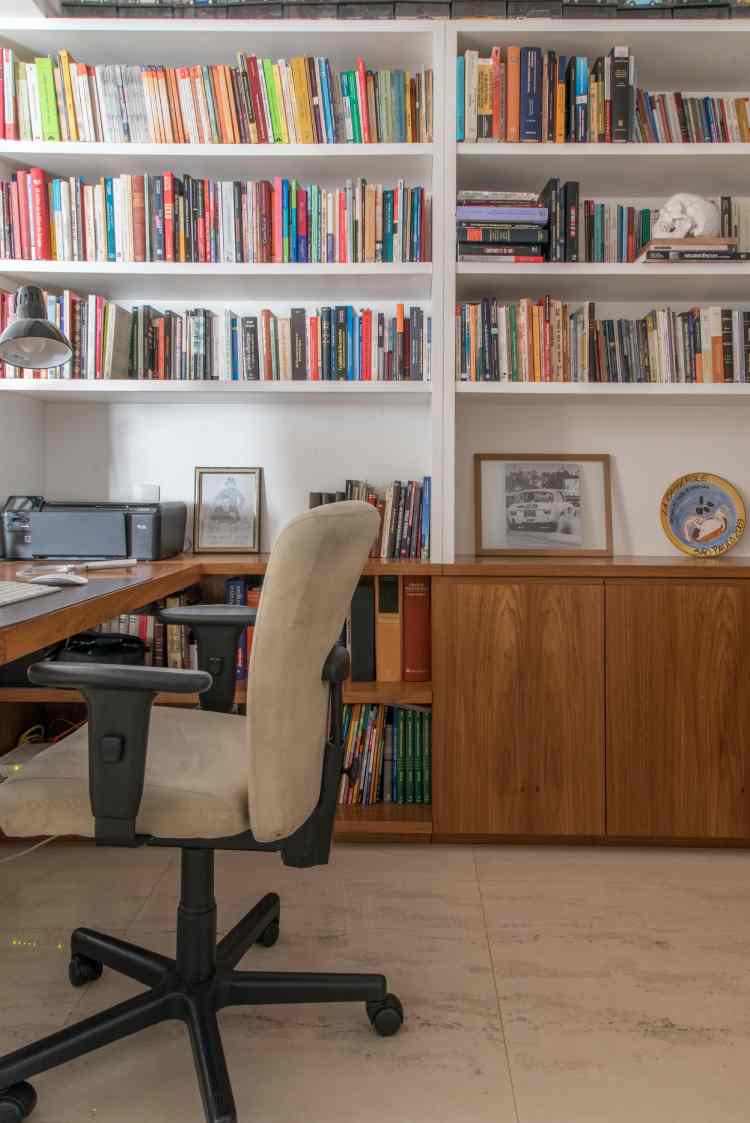 reading corner with wall of bookshelves and white desk next to it