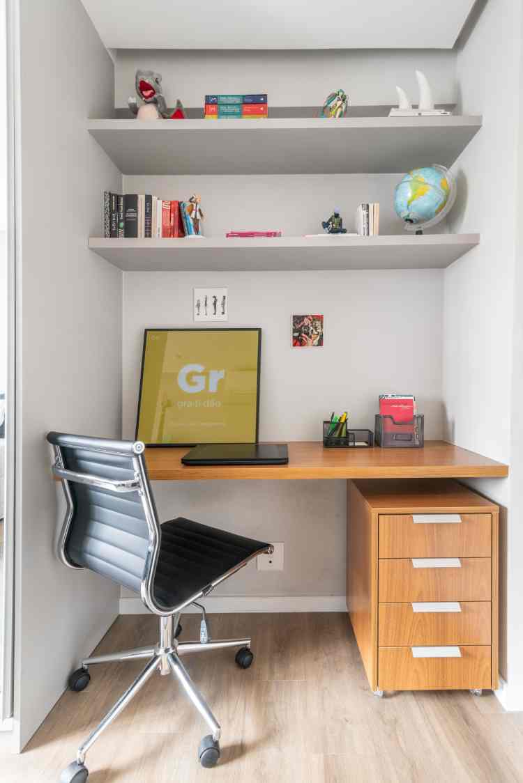 wooden desk, black chair and white bookshelf with books