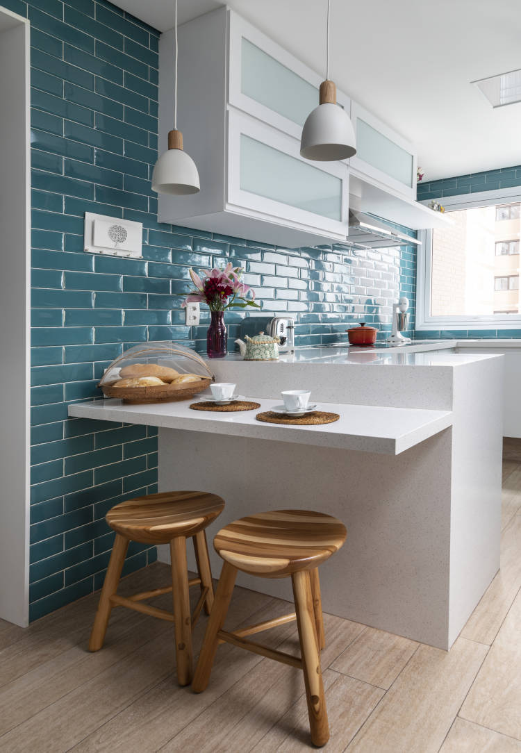 Kitchen with turquoise blue wall and white furniture.