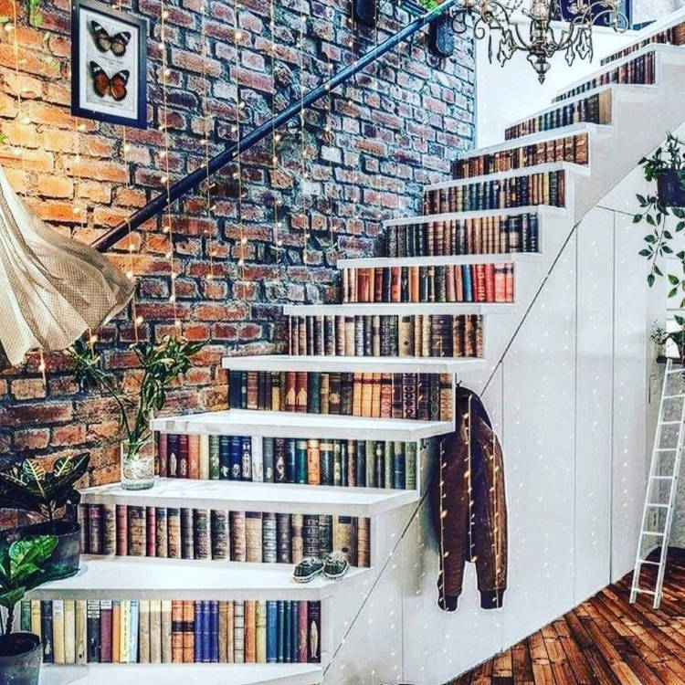 Staircase with books and handrail on the wall.