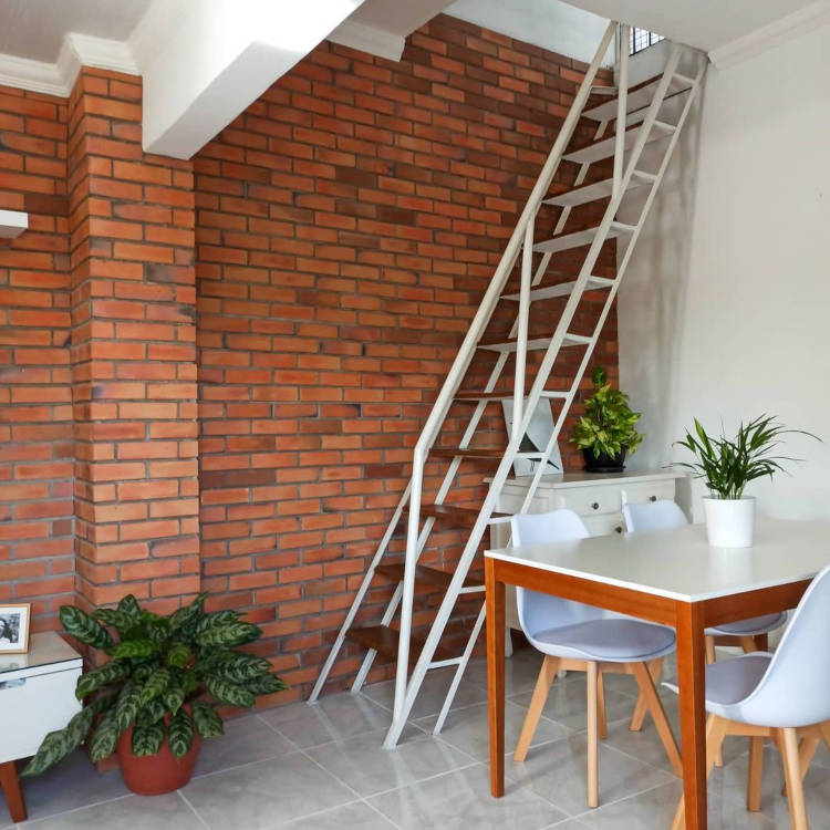 Staircase wall with exposed bricks.