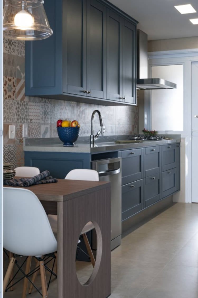 Small kitchen with tile covering and blue cabinet.