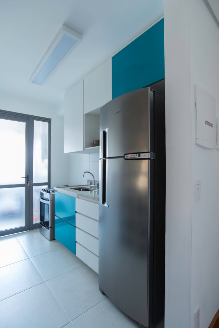 Small blue kitchen with white cabinets.