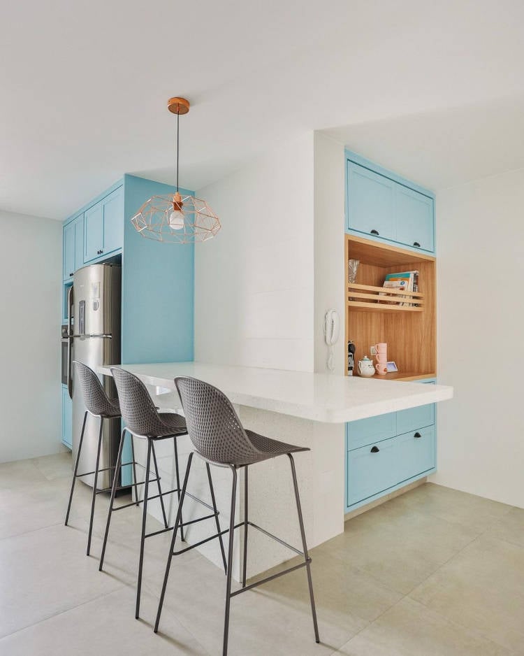 Kitchen corner with blue cabinets and high countertop.