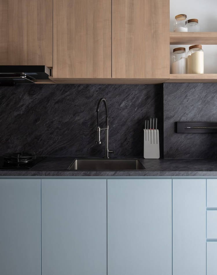 Space with dark coating behind the sink.