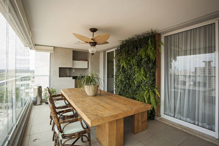 Balcony with barbecue and rustic wooden table.