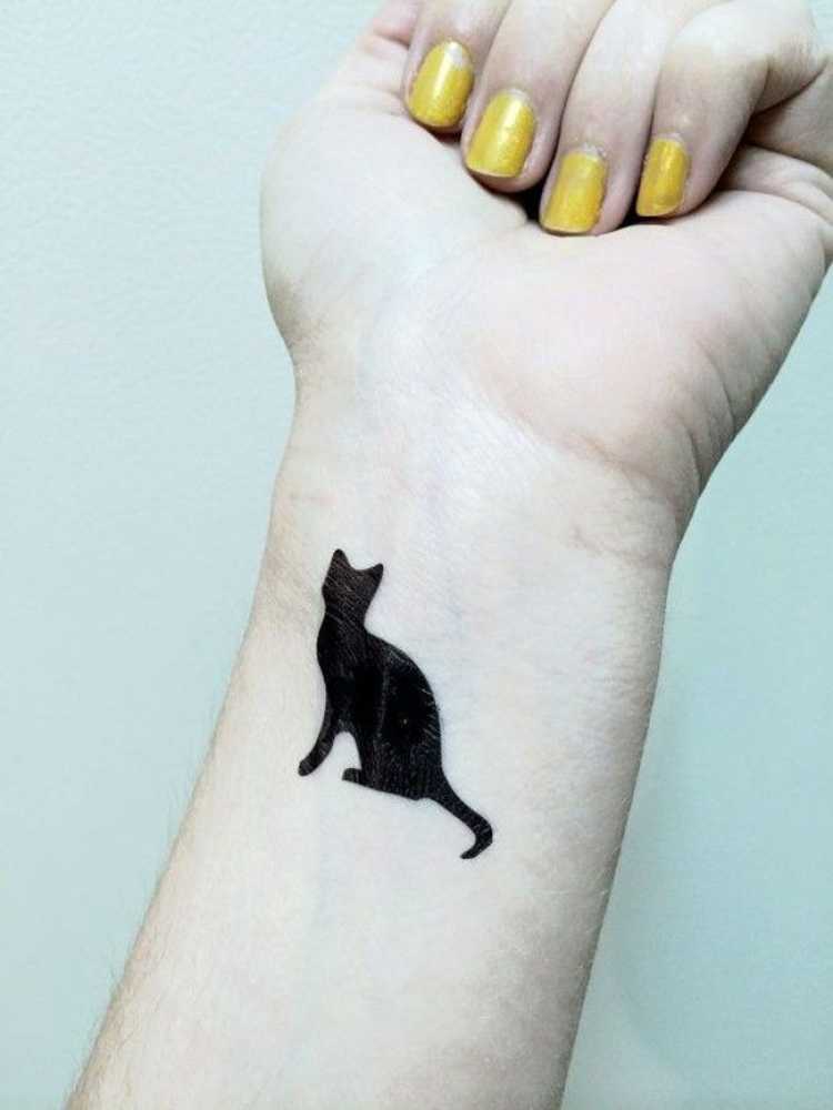 Tattoo with a drawing of a black cat on the wrist