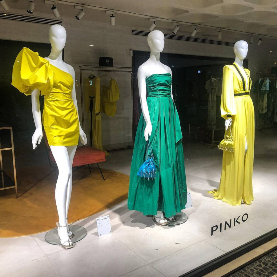 Designer store with yellow and green dresses.