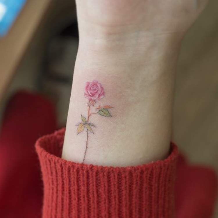 Delicate flower tattoo on arm