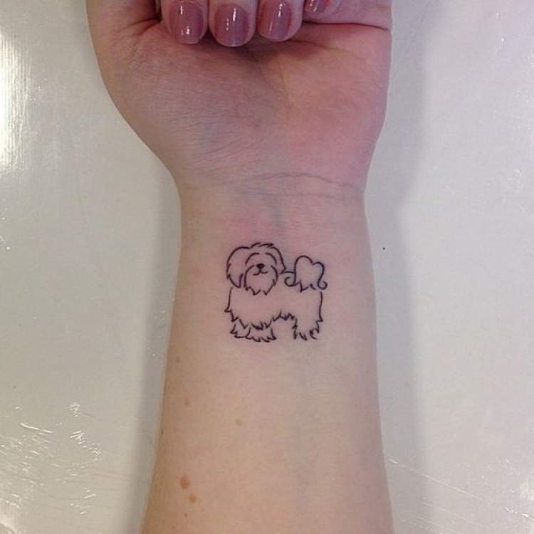 Delicate dog tattoo on wrist