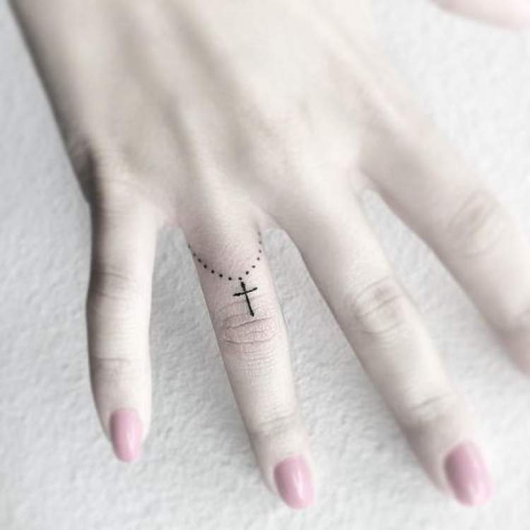 Religious tattoo on finger