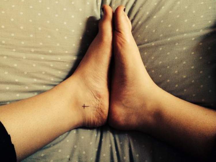 Cross tattooed on the side of the foot