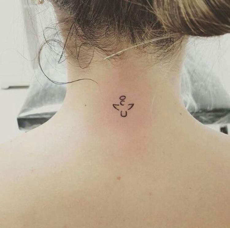 Delicate religious tattoo behind the neck