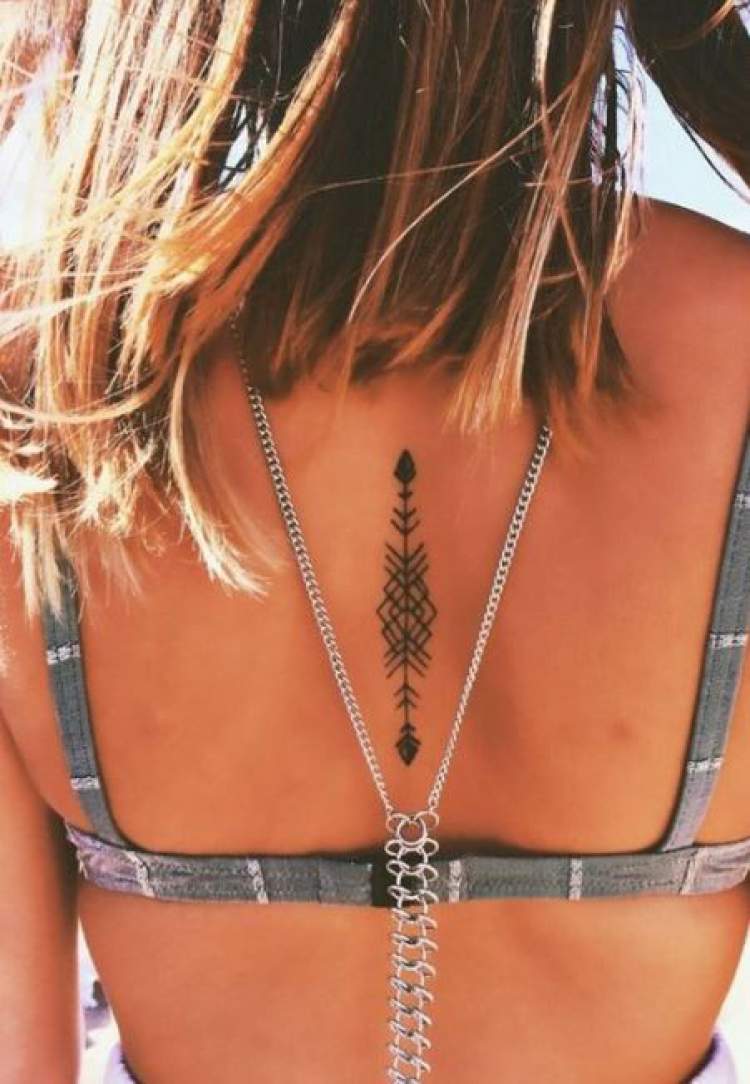 Delicate back tattoo with an arrow design