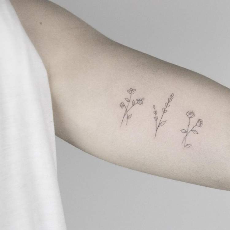 Flowers and plants tattooed on the arm