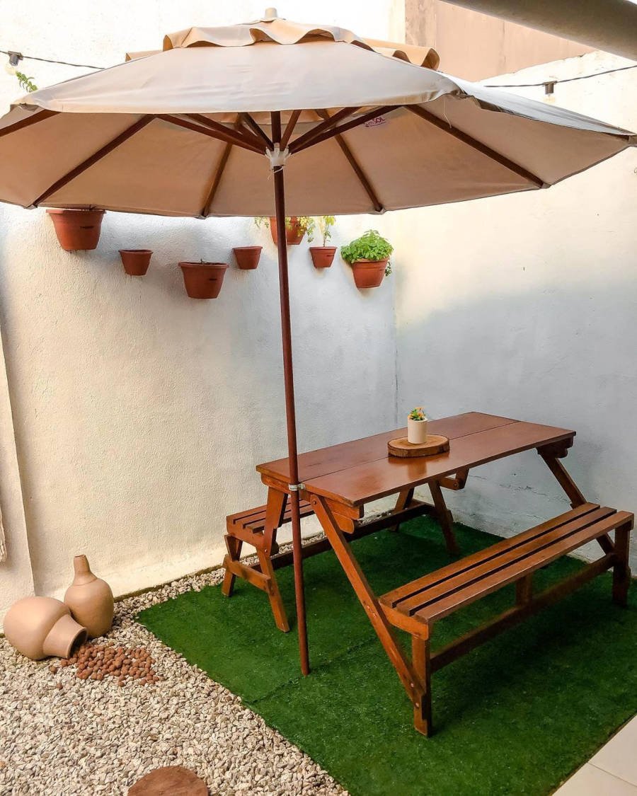 Backyard with wooden table and umbrella.