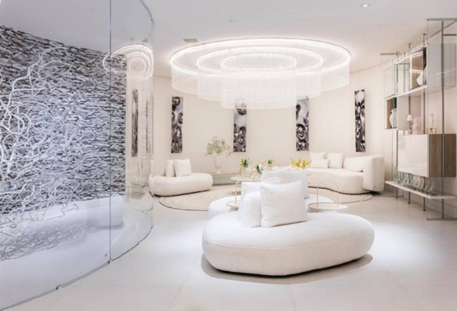 White room with round chandelier at CASACOR SP.