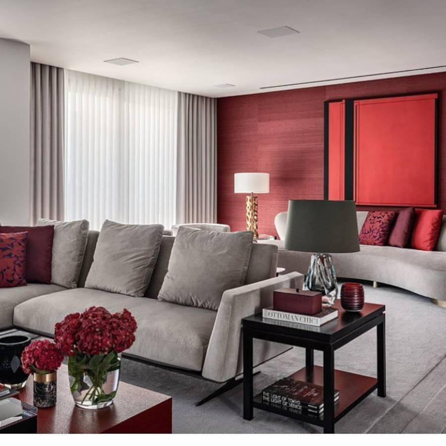 Living room with two gray sofas and red details.