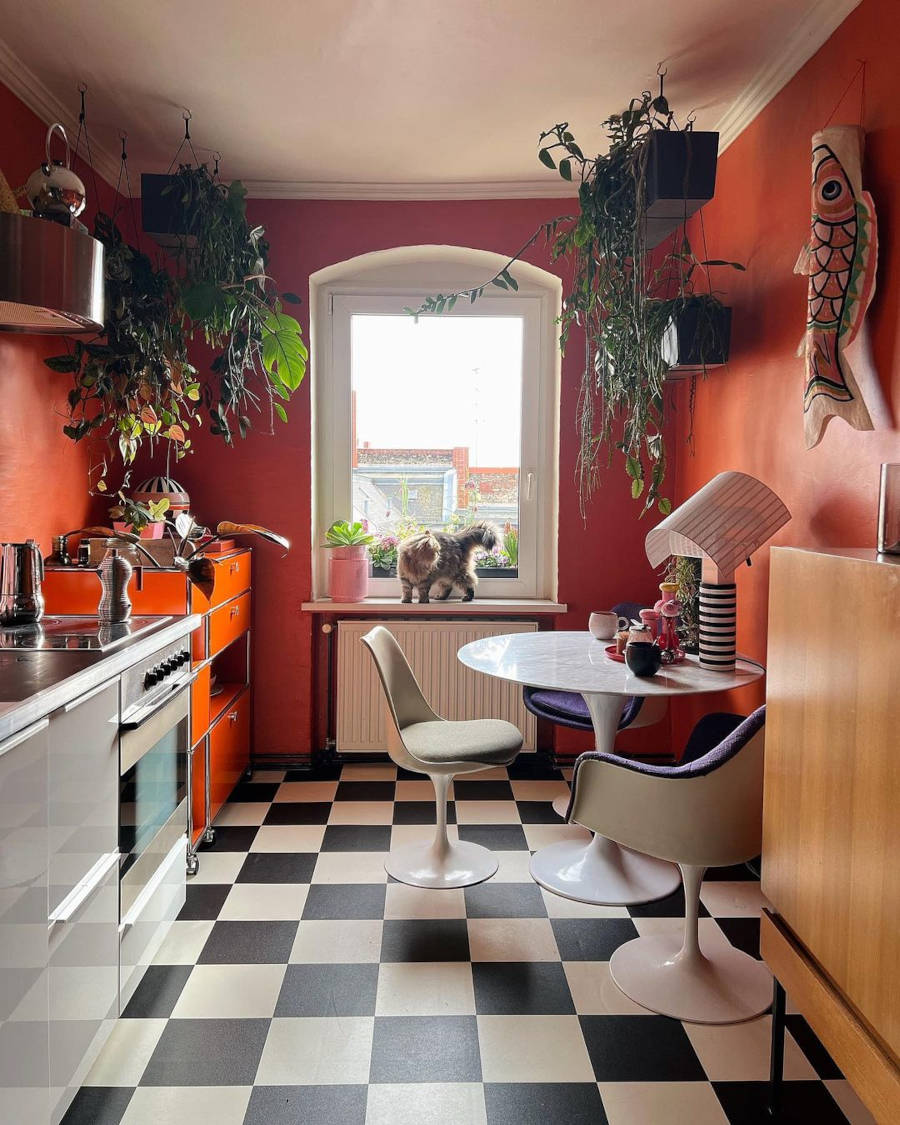 Kitchen with checkered floors and orange walls.