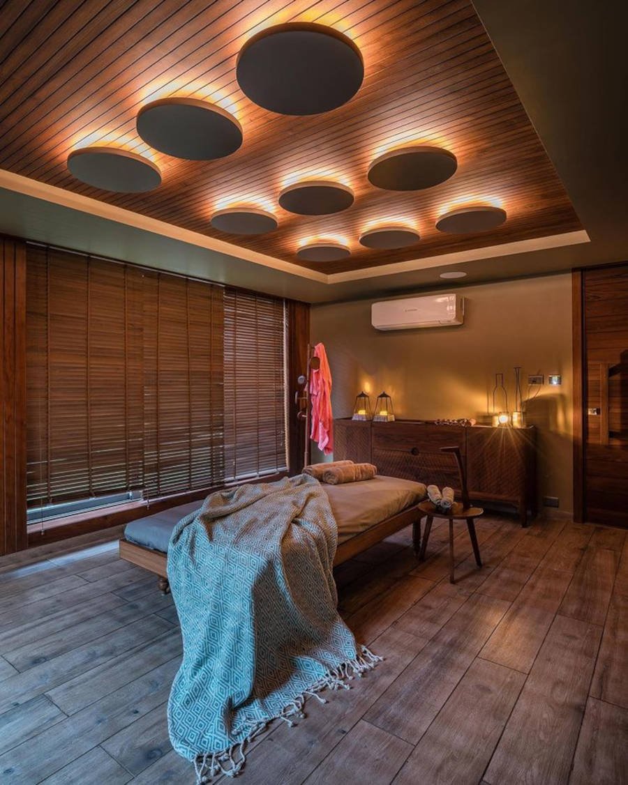 Large massage room lit with LED spotlights and candles.