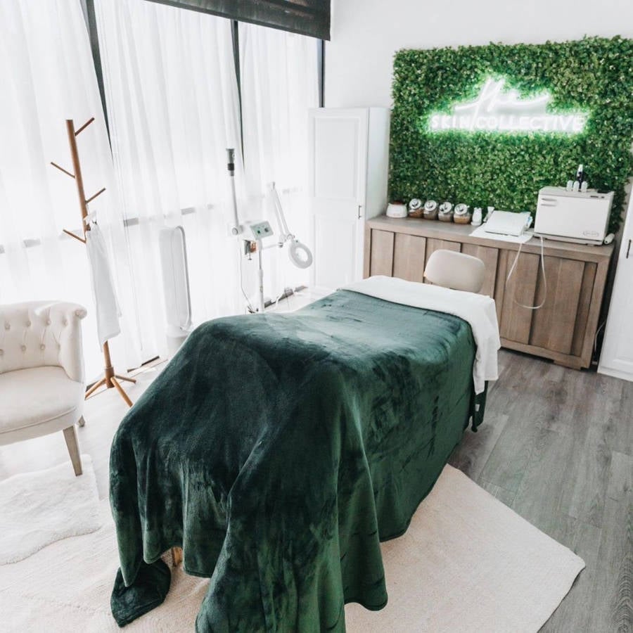 Massage room with green wall and neon sign.