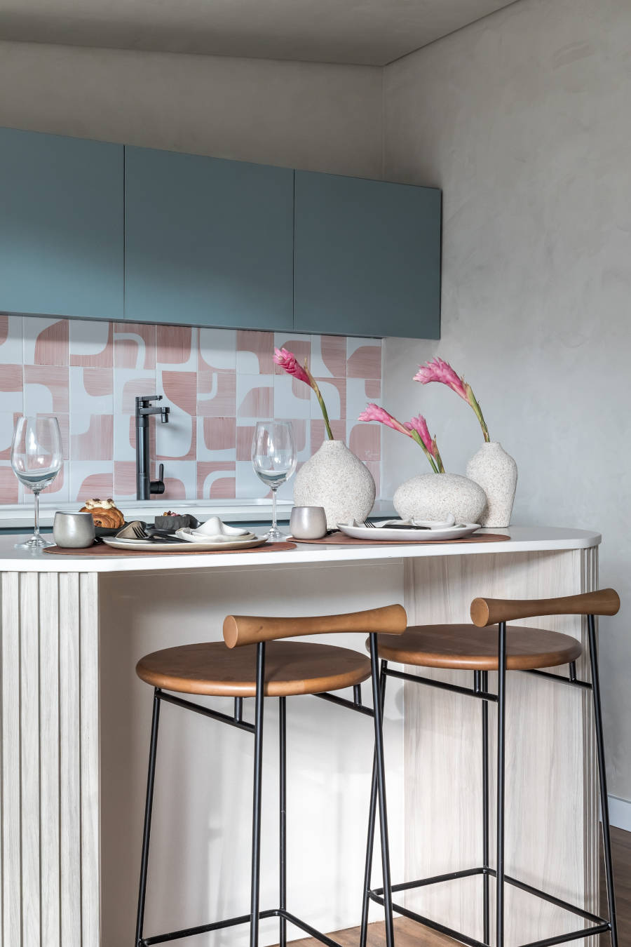 Close-up photo of the kitchen with personality decorated with vases of pink flowers.