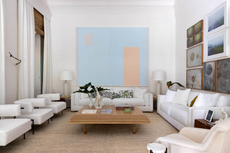 White room with paintings at CASACOR Rio.