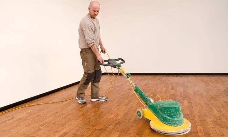 Man cleaning parquet floor.