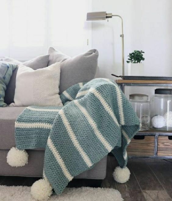 Gray sofa with striped blanket.