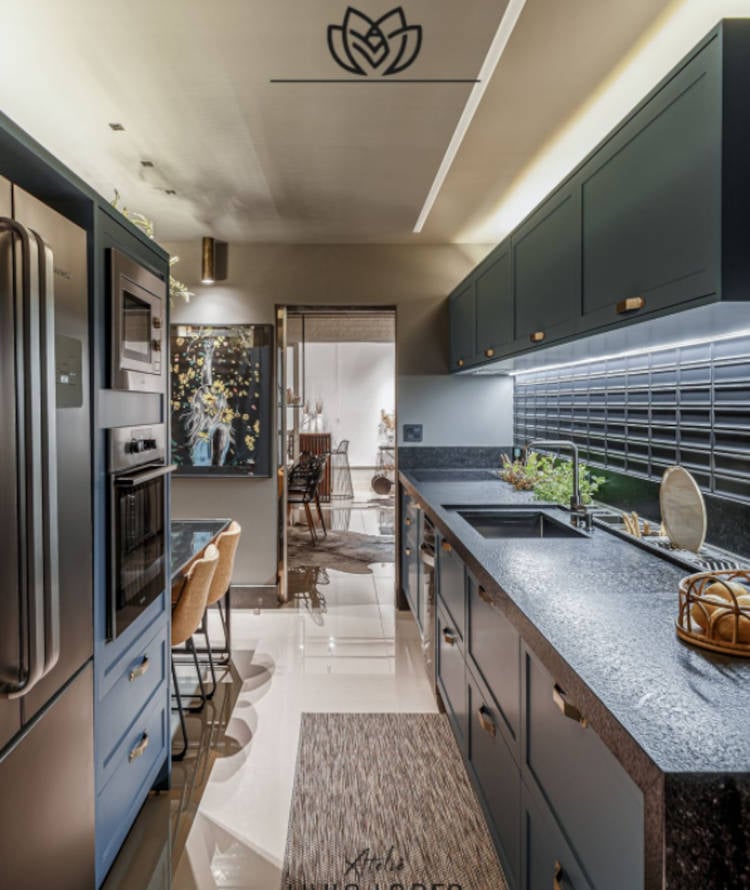 Narrow kitchen with dark furniture.