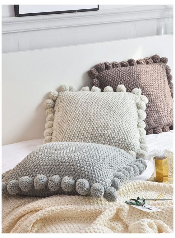 Three cushions in neutral tones.