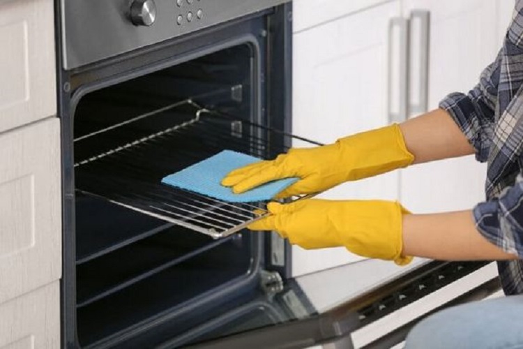 Woman cleaning the stove grates.