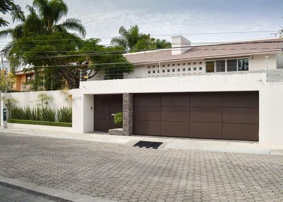 Residential wall with wide brown gates.