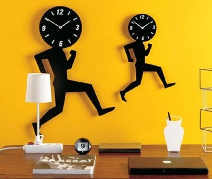 Pared amarilla con reloj negro.